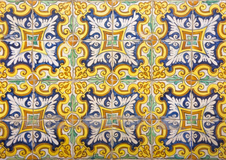 Decorative ceramic tiles with a repeating pattern in yellow, blue, green, and white geometric and floral motifs.